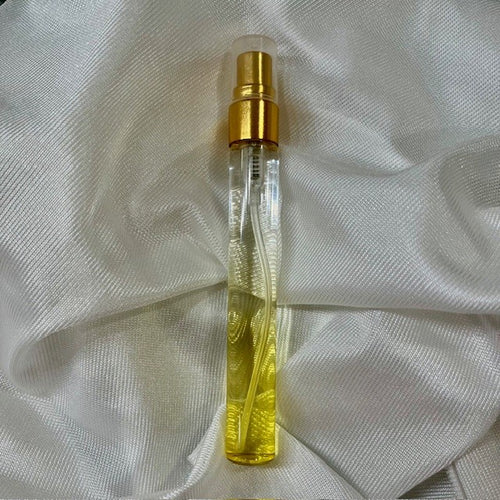Small perfume bottle with gold cap on a white fabric background