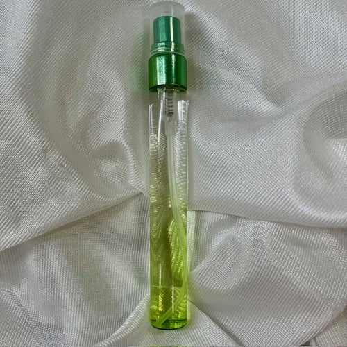 Clear spray bottle with green cap on a white textured fabric background